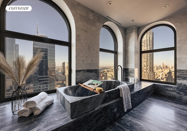 bathroom featuring a city view, a bath, and visible vents