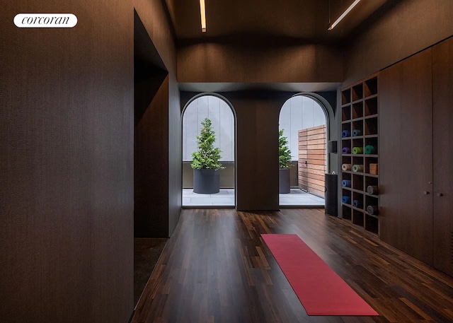 foyer entrance with wood finished floors and a towering ceiling