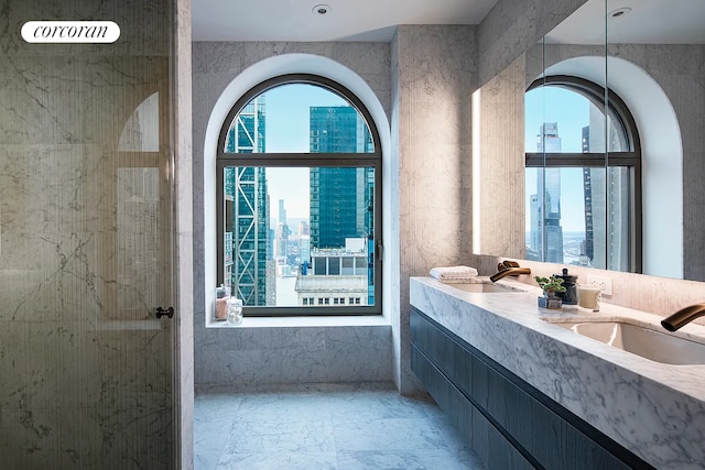 130 William St Unit 43C, New York City, NY 10038 - full bathroom featuring a view of city, double vanity, marble finish flooring, and a shower