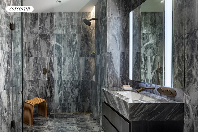 130 William St Unit 43C, New York City, NY 10038 - full bath featuring tile walls, marble tiled flooring, vanity, and a marble finish shower
