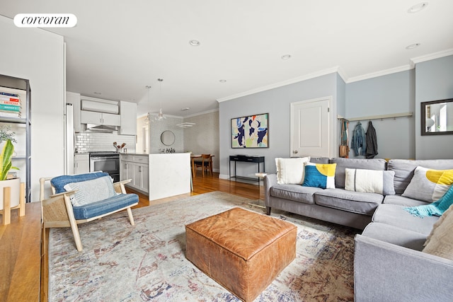 living room with light wood finished floors, crown molding, recessed lighting, and baseboards