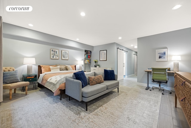 bedroom featuring a barn door, an office area, and recessed lighting
