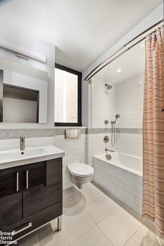 345 E 57th St Unit 8Ab, New York City, NY 10022 - full bathroom featuring tiled shower / bath combo, tile walls, vanity, toilet, and tile patterned flooring