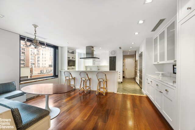 345 E 57th St Unit 8Ab, New York City, NY 10022 - dining space with dark wood-style floors, a chandelier, and recessed lighting