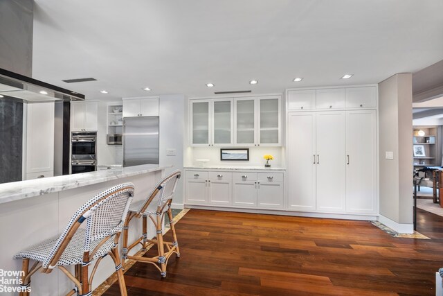 345 E 57th St Unit 8Ab, New York City, NY 10022 - kitchen featuring appliances with stainless steel finishes, dark wood-type flooring, white cabinetry, and recessed lighting