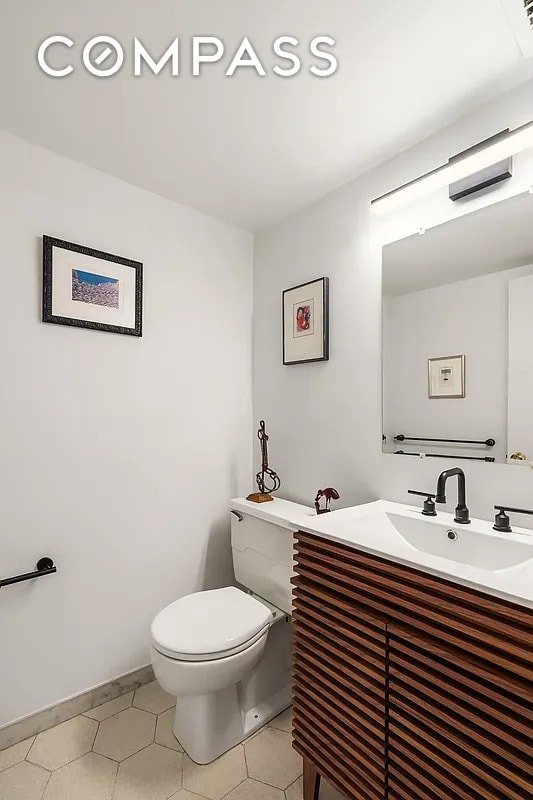 half bathroom with toilet and vanity