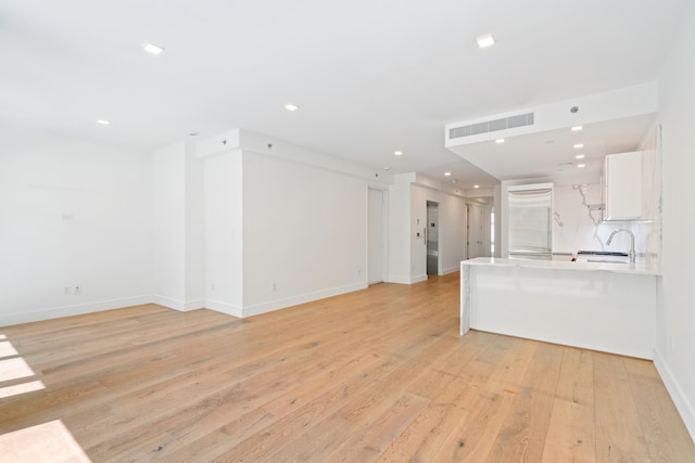 245 E 53rd St Unit 2, New York City, NY 10022 - unfurnished living room with light wood-style flooring, a sink, baseboards, and recessed lighting