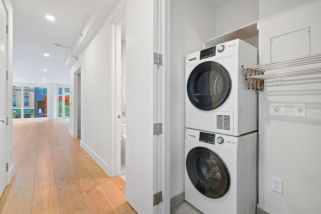 245 E 53rd St Unit 2, New York City, NY 10022 - washroom with stacked washer and clothes dryer, light wood-type flooring, recessed lighting, and baseboards