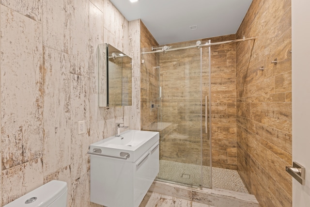 245 E 53rd St Unit 2, New York City, NY 10022 - bathroom with vanity, a shower stall, toilet, and tile walls