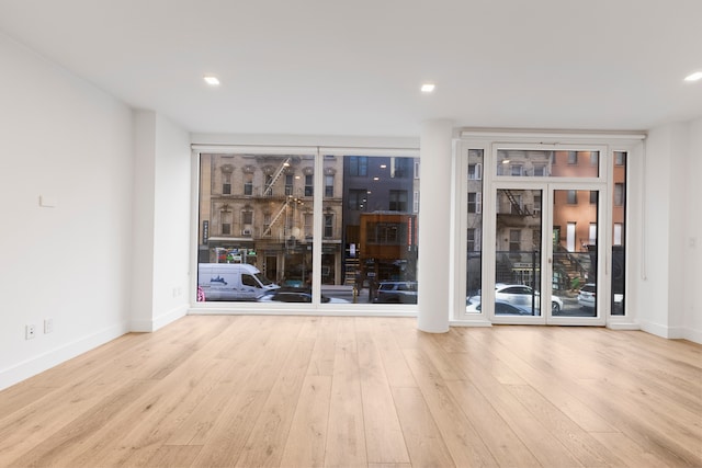 empty room featuring wood finished floors, baseboards, and recessed lighting