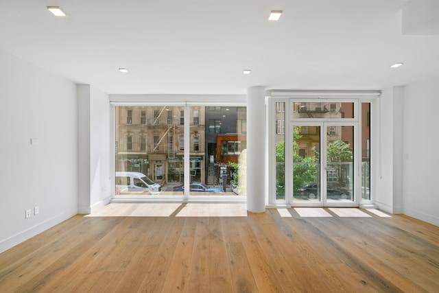245 E 53rd St Unit 2, New York City, NY 10022 - empty room with wood finished floors, baseboards, and expansive windows