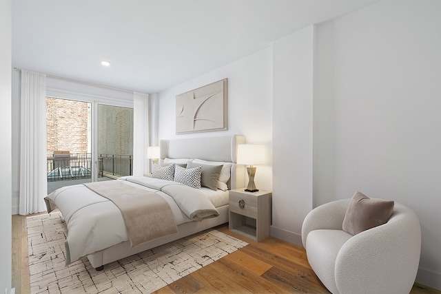 245 E 53rd St Unit 2, New York City, NY 10022 - bedroom featuring light wood-style floors, access to exterior, baseboards, and recessed lighting