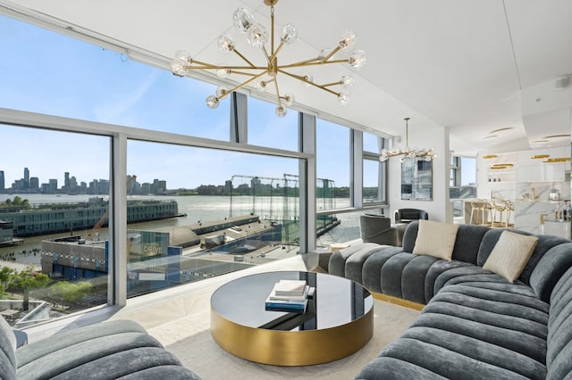living room featuring a chandelier, a skyline view, a water view, and a wall of windows