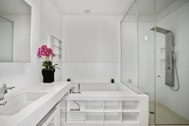 bathroom featuring a shower stall, a garden tub, and vanity
