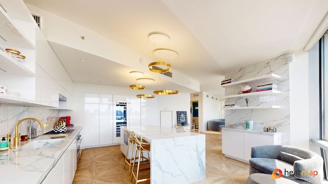 100 11th Ave Unit 12-B, New York City, NY 10011 - kitchen with open shelves, white cabinets, modern cabinets, and backsplash