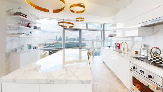 100 11th Ave Unit 12-B, New York City, NY 10011 - kitchen with open shelves, oven, modern cabinets, and white cabinets