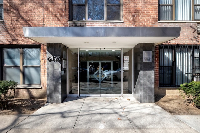view of exterior entry with brick siding