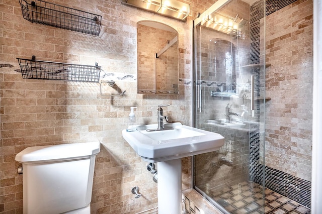 full bath with a stall shower, toilet, and tile walls