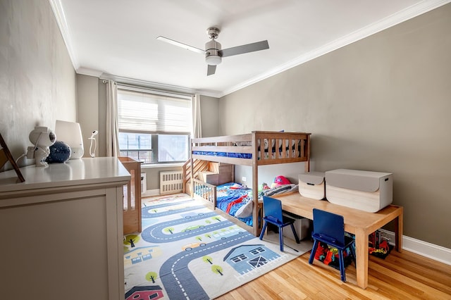 bedroom featuring radiator heating unit, baseboards, ornamental molding, and wood finished floors