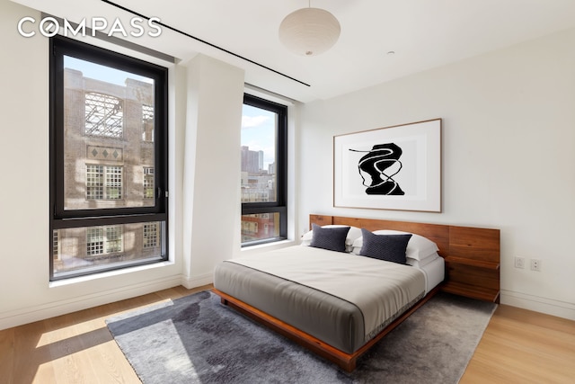 bedroom featuring wood finished floors and baseboards