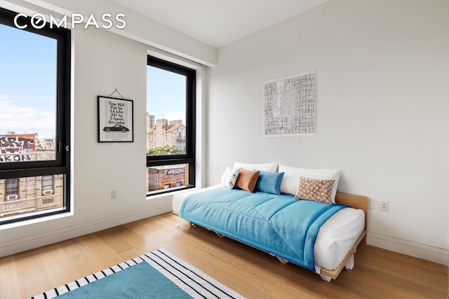 bedroom with wood finished floors and baseboards