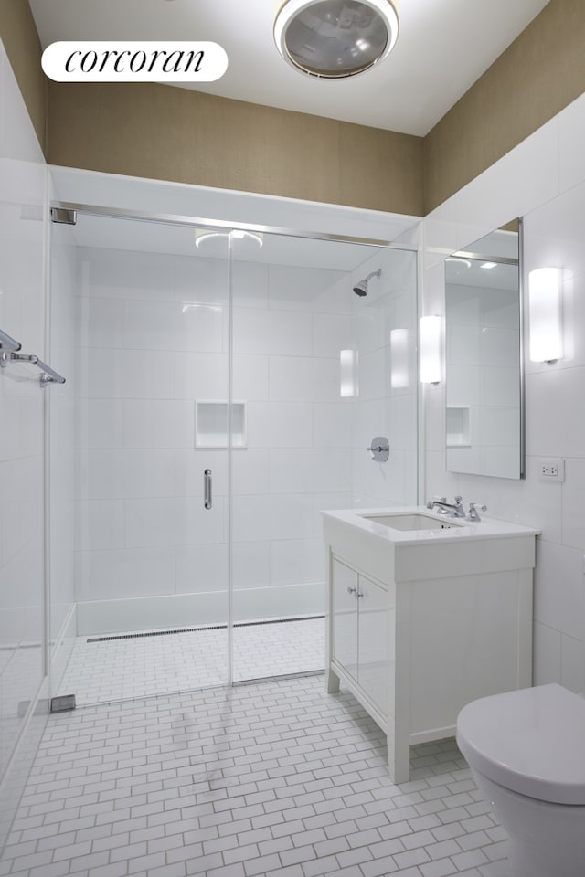 bathroom featuring vanity, a stall shower, and toilet
