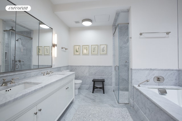 full bath with a sink, a shower stall, toilet, and a bath