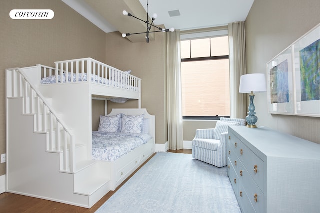 bedroom with an inviting chandelier, wood finished floors, and visible vents