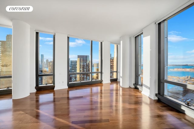 101 Warren St Unit 1720, New York City, NY 10007 - unfurnished room featuring floor to ceiling windows, a skyline view, wood finished floors, and healthy amount of natural light