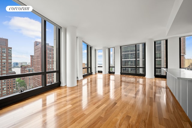 101 Warren St Unit 1720, New York City, NY 10007 - empty room featuring expansive windows, light wood-type flooring, and a view of city