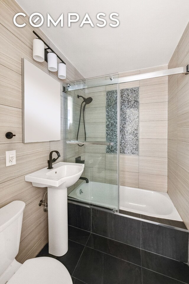 340 E 80th St Unit 1D, New York City, NY 10075 - bathroom featuring tile walls, tiled shower / bath combo, and tile patterned floors