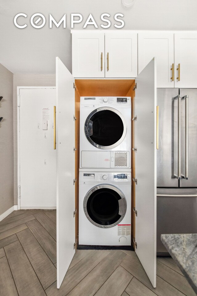 340 E 80th St Unit 1D, New York City, NY 10075 - laundry area with stacked washer and clothes dryer and baseboards
