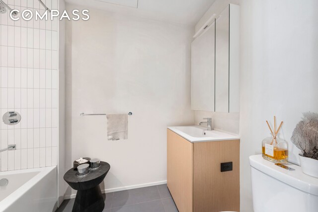 bathroom with vanity, shower / bath combination, tile patterned floors, toilet, and baseboards