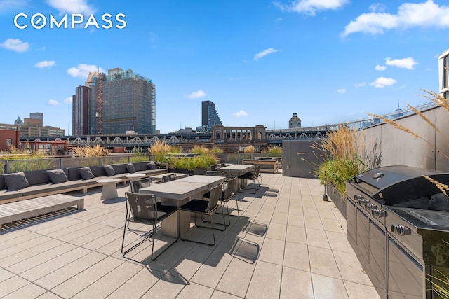 view of patio / terrace featuring a view of city, area for grilling, and outdoor dining area