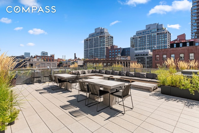 view of patio / terrace featuring a city view, an outdoor living space, and outdoor dining area