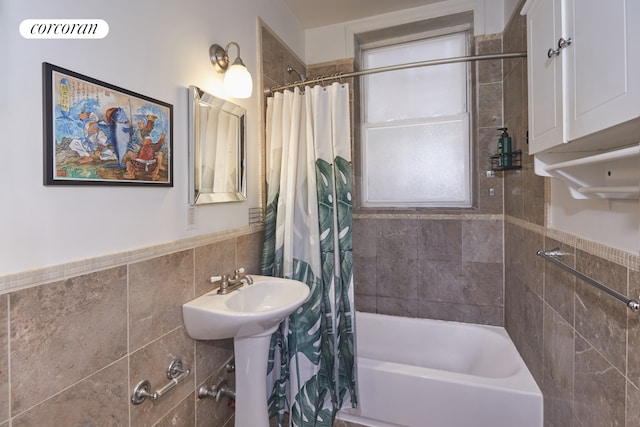 658 Park Pl Unit 1, New York City, NY 11216 - full bath featuring tile walls, shower / tub combo with curtain, wainscoting, and a sink