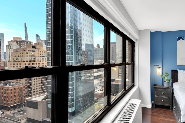 interior space with a view of city, baseboards, and wood finished floors