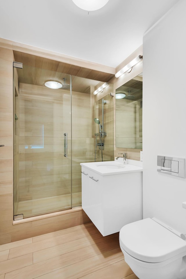 full bath featuring vanity, a stall shower, and toilet