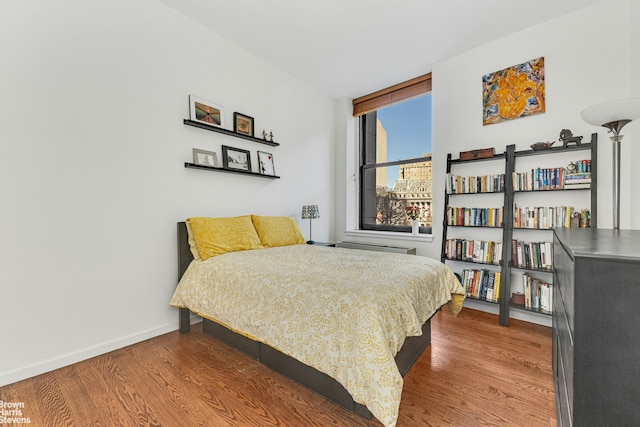 bedroom with wood finished floors and baseboards