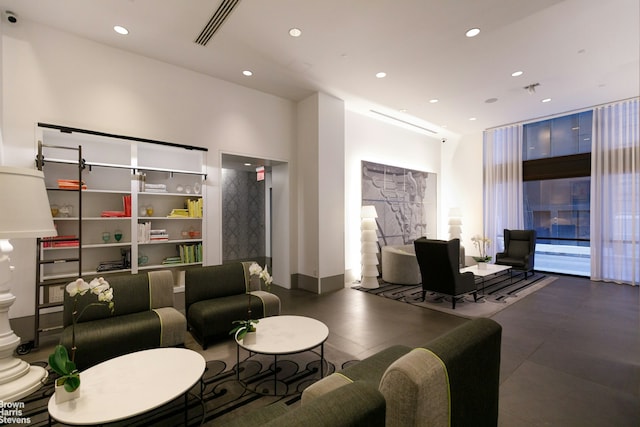 building lobby featuring recessed lighting, a towering ceiling, and a surveillance system