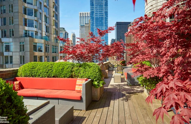 surrounding community with an outdoor living space, a wooden deck, and a city view