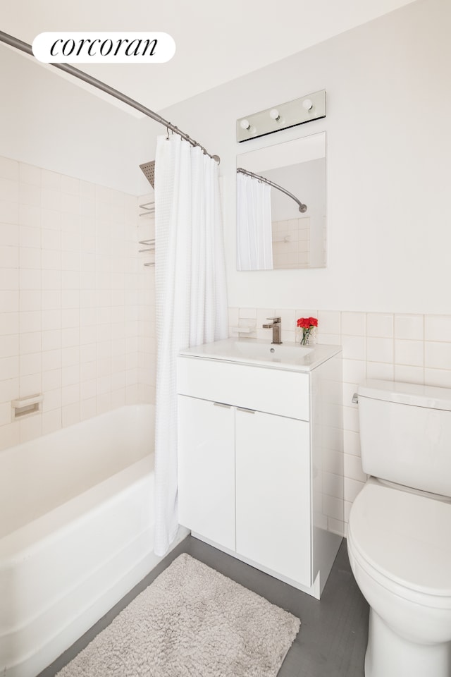 415 E 52nd St Unit 11Fc, New York City, NY 10022 - bathroom featuring shower / bathtub combination with curtain, vanity, toilet, and tile walls