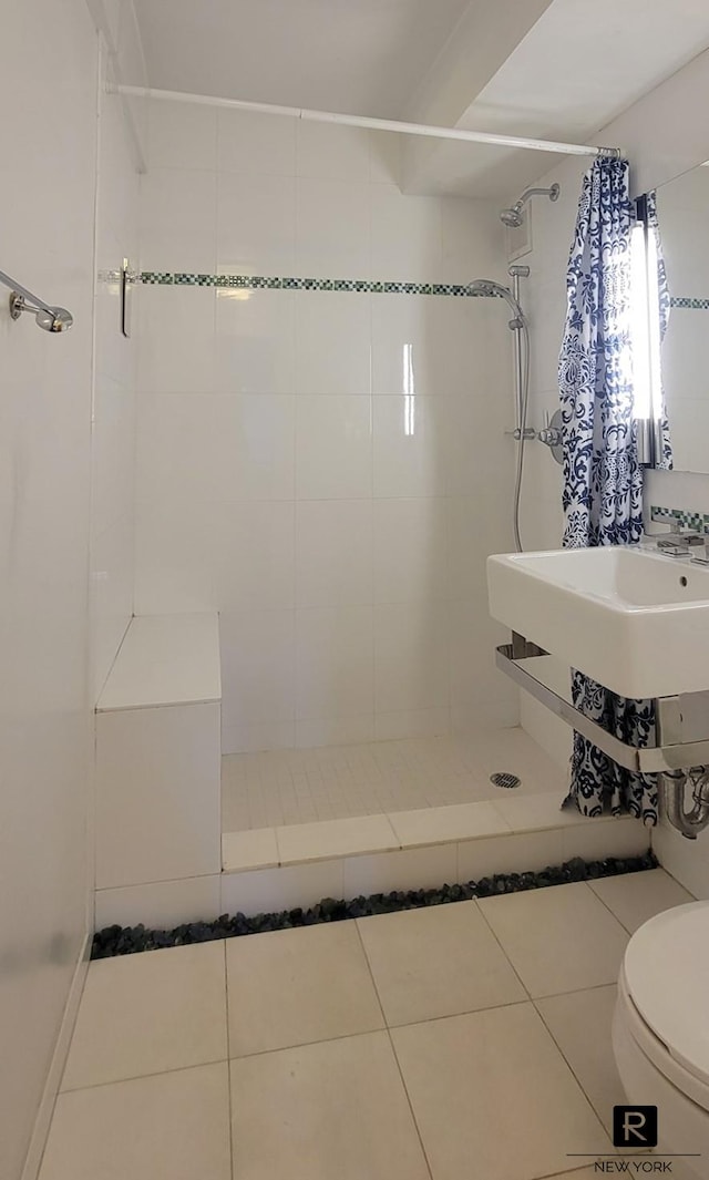 full bath featuring tile patterned floors, toilet, and tiled shower