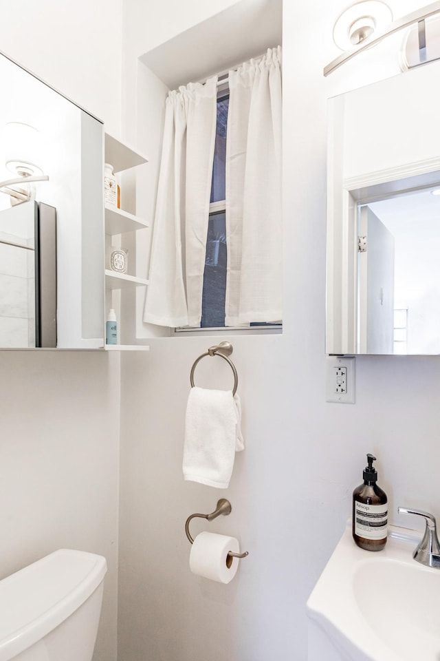 bathroom with toilet and a sink