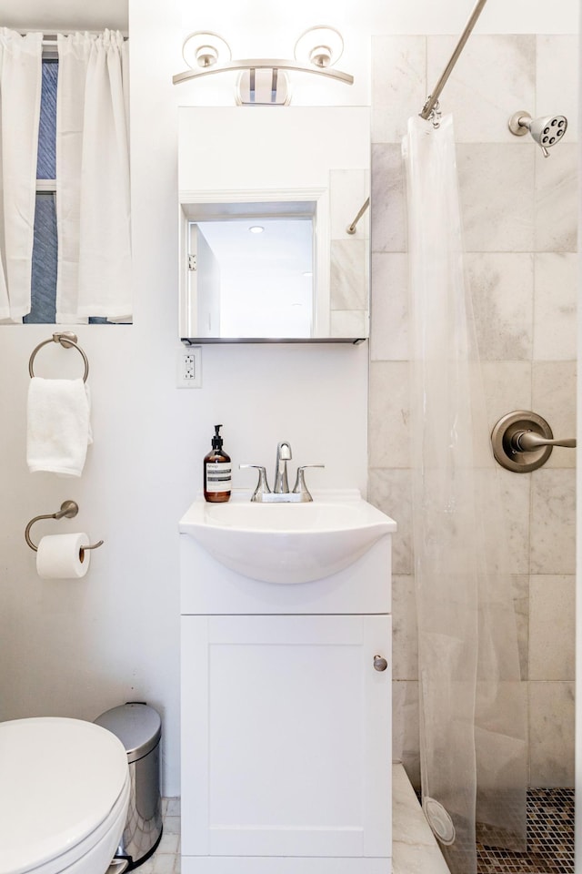 full bathroom with vanity, toilet, and tiled shower
