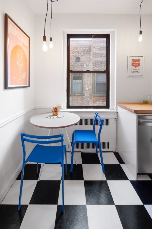dining space featuring radiator heating unit and tile patterned floors