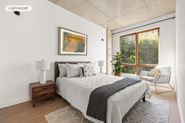 bedroom with wood finished floors and baseboards