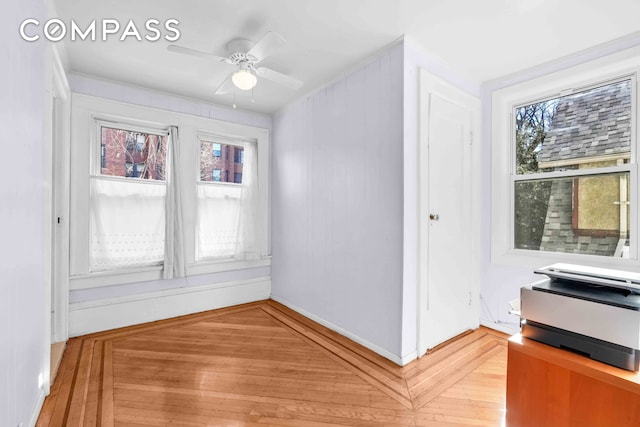 unfurnished room featuring light wood-style flooring, ceiling fan, and baseboards