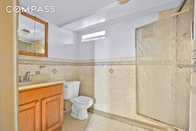 bathroom with tile patterned flooring, a shower stall, tile walls, toilet, and a wainscoted wall