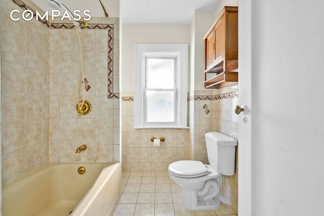bathroom featuring tile walls, tile patterned floors, toilet, a wainscoted wall, and  shower combination